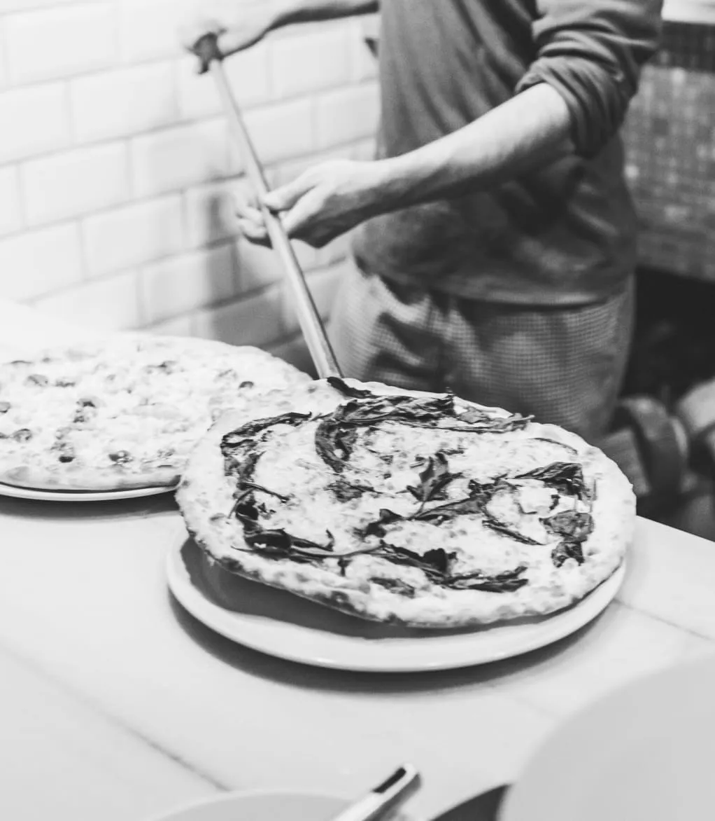 Thin pizza coming out from the oven